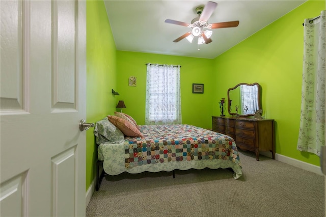 carpeted bedroom with a ceiling fan and baseboards