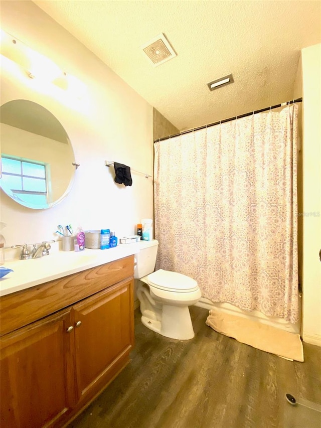 bathroom with wood-type flooring, toilet, a textured ceiling, and vanity