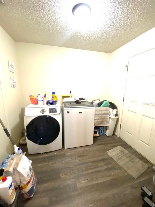 laundry area featuring wood-type flooring, washer and clothes dryer, and a textured ceiling