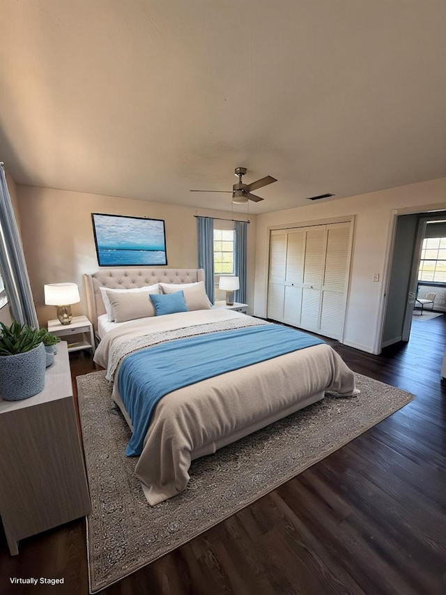 bedroom featuring dark hardwood / wood-style floors, ceiling fan, and a closet