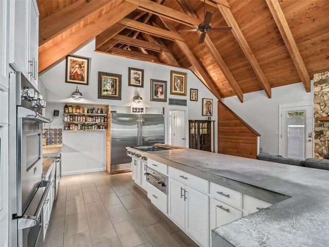 kitchen with appliances with stainless steel finishes, ceiling fan, wooden ceiling, beamed ceiling, and white cabinets