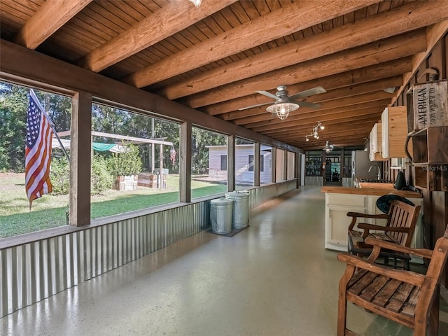 sunroom / solarium with beamed ceiling, ceiling fan, and wood ceiling