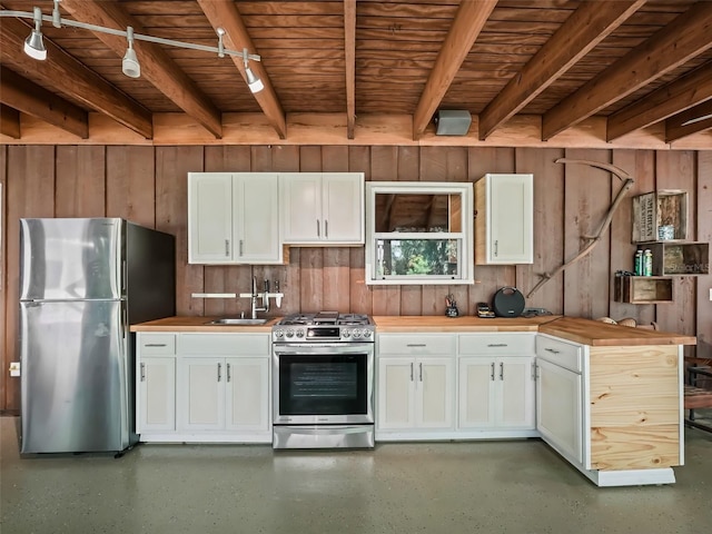 kitchen featuring white cabinets, butcher block counters, and appliances with stainless steel finishes