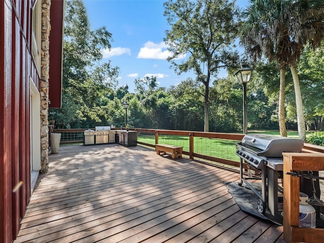 wooden terrace featuring a lawn and area for grilling