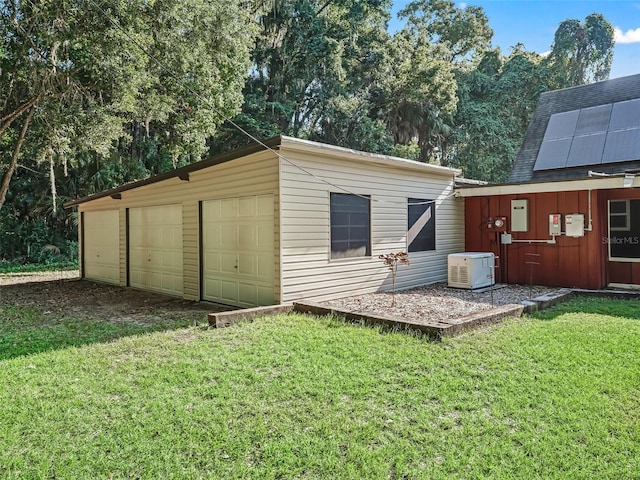 garage featuring a lawn and solar panels