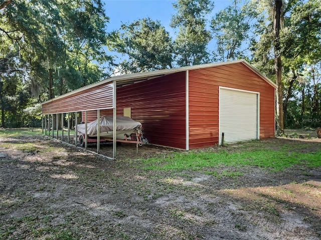 view of outdoor structure with a carport and a garage