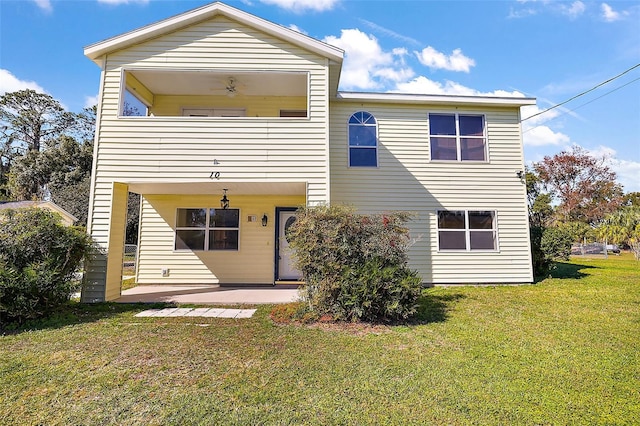 rear view of property with a patio and a lawn