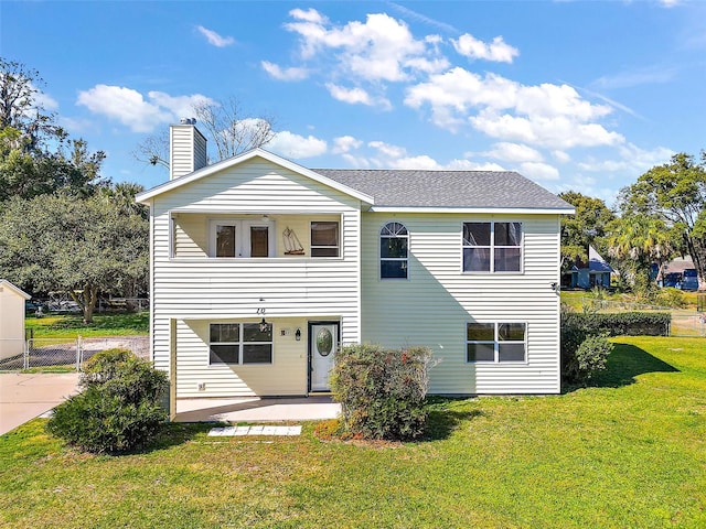 rear view of property featuring a lawn