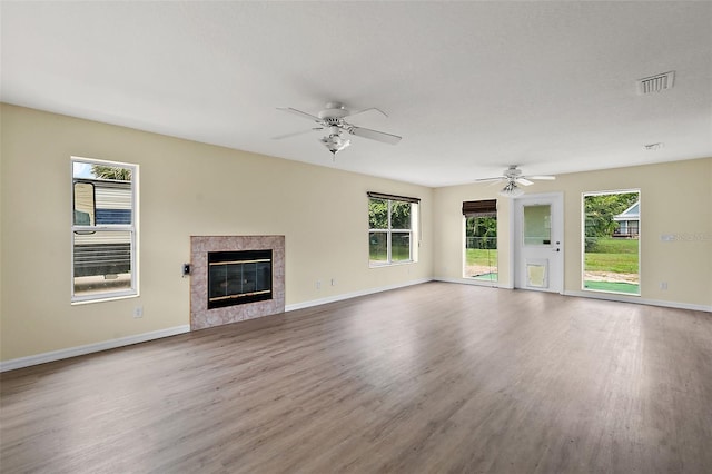 unfurnished living room with ceiling fan, light hardwood / wood-style flooring, and a high end fireplace