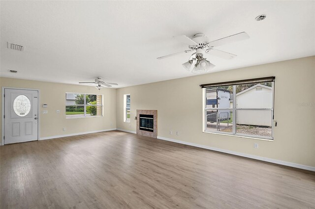 unfurnished living room featuring ceiling fan and hardwood / wood-style flooring