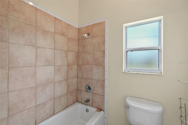 bathroom with toilet and tiled shower / bath combo