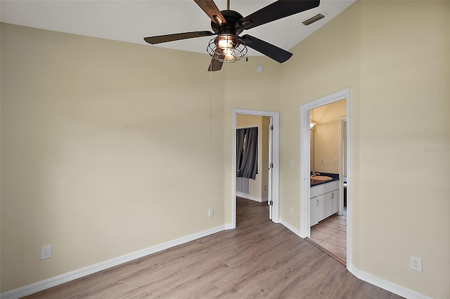 spare room featuring light tile patterned floors, vaulted ceiling, sink, and ceiling fan