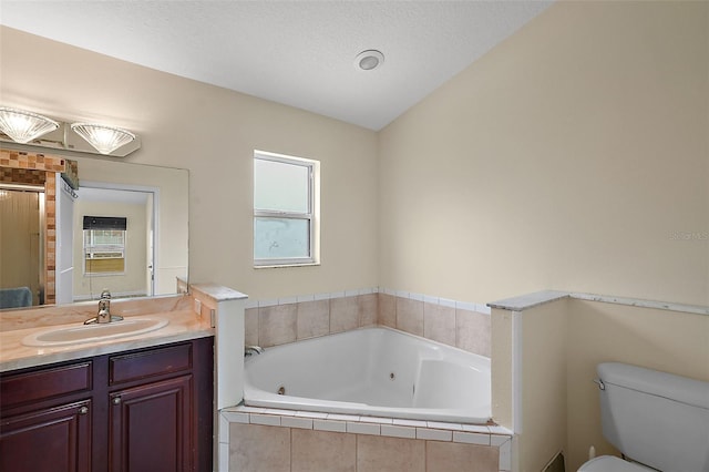 bathroom featuring toilet, a textured ceiling, a jetted tub, and vanity