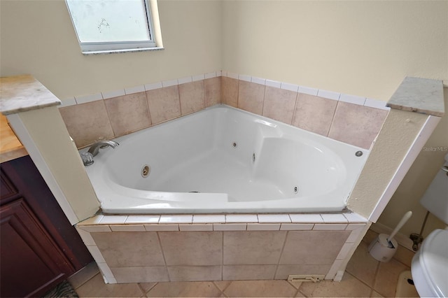 bathroom with toilet, tiled tub, tile patterned flooring, and vanity