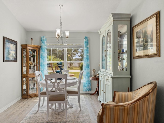 dining room with light wood-type flooring and a chandelier