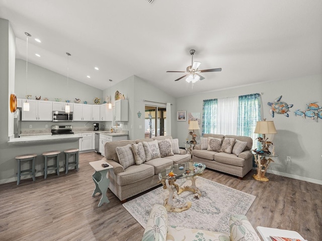 living room featuring high vaulted ceiling, ceiling fan, sink, and light hardwood / wood-style flooring