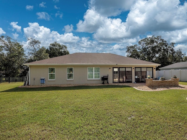 rear view of property with a lawn and a sunroom