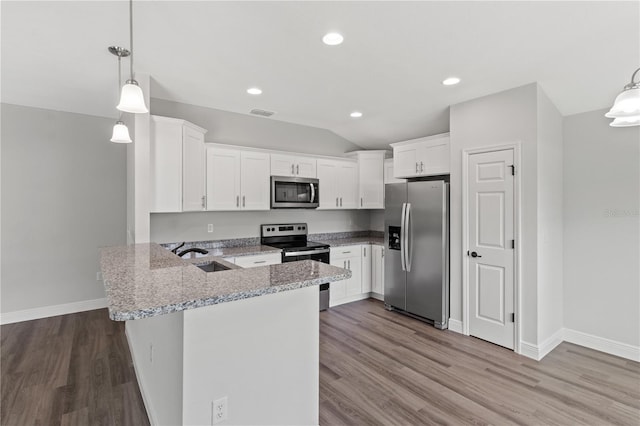 kitchen with light wood-type flooring, light stone counters, decorative light fixtures, kitchen peninsula, and stainless steel appliances