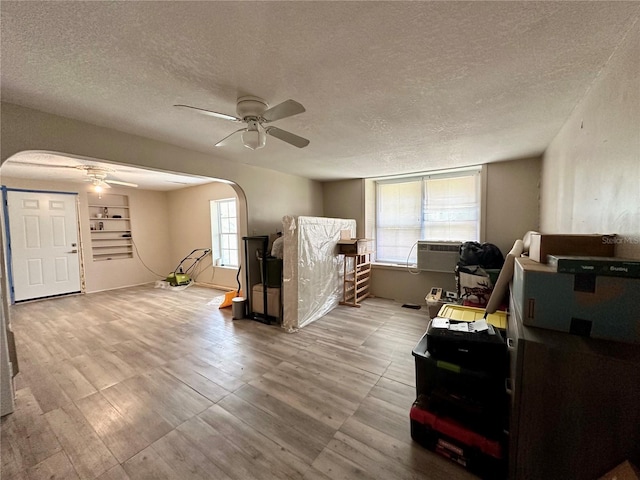 interior space featuring a healthy amount of sunlight, a textured ceiling, ceiling fan, and light hardwood / wood-style flooring