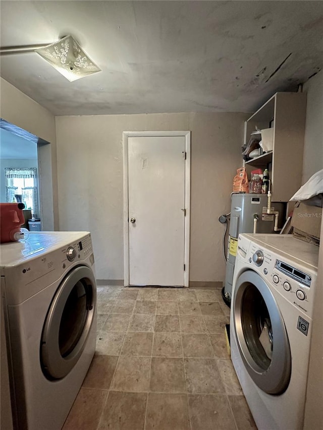 laundry room featuring washer and clothes dryer, light tile patterned floors, and electric water heater