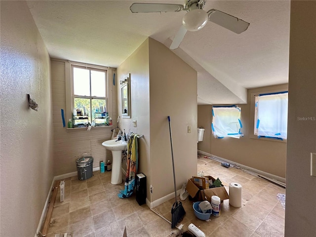 interior space with ceiling fan, sink, a textured ceiling, and tile patterned floors