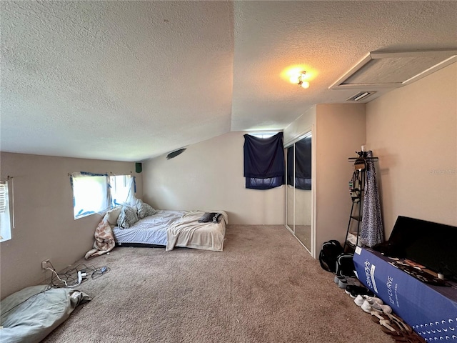 carpeted bedroom featuring a textured ceiling and lofted ceiling