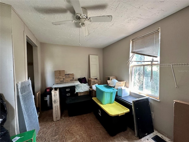 bedroom with ceiling fan and a textured ceiling