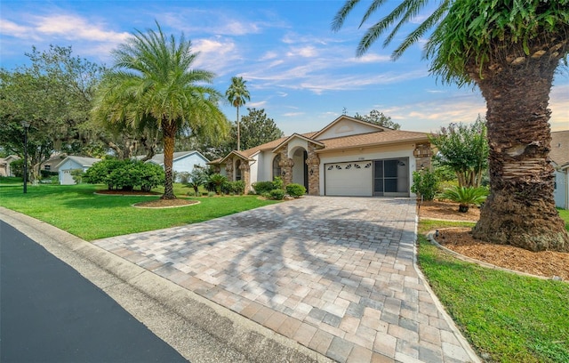 single story home with a garage and a front lawn