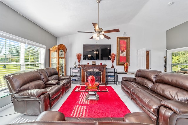 living room with a wealth of natural light, a fireplace, lofted ceiling, and ceiling fan