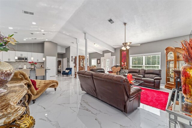 living room with a textured ceiling, visible vents, a ceiling fan, vaulted ceiling, and marble finish floor