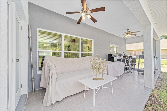 living area with ceiling fan, plenty of natural light, and light tile patterned floors