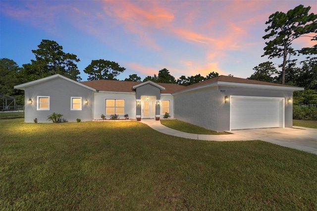 ranch-style home with a front lawn, driveway, an attached garage, and stucco siding