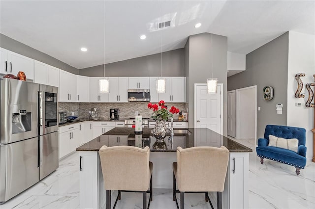 kitchen with a breakfast bar area, stainless steel appliances, visible vents, white cabinetry, and marble finish floor