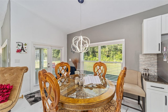 dining space featuring vaulted ceiling, plenty of natural light, french doors, and an inviting chandelier