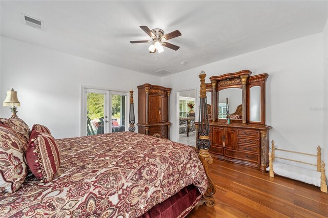 bedroom featuring multiple windows, wood finished floors, visible vents, and access to exterior