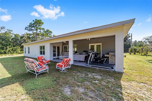 rear view of house featuring a yard, french doors, and a patio area