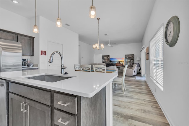 kitchen with light countertops, a sink, visible vents, and light wood-style floors