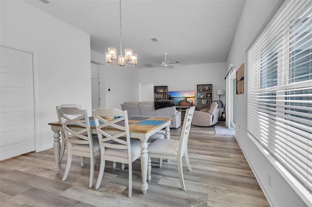 dining room with light wood finished floors, visible vents, and ceiling fan with notable chandelier