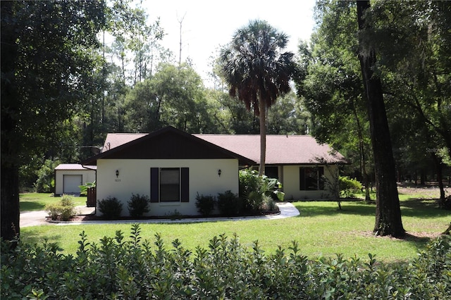 ranch-style home with an outdoor structure, a garage, and a front yard