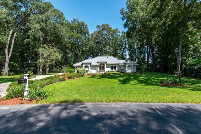 single story home featuring a front lawn