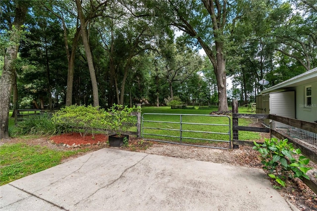 view of gate featuring a lawn and fence