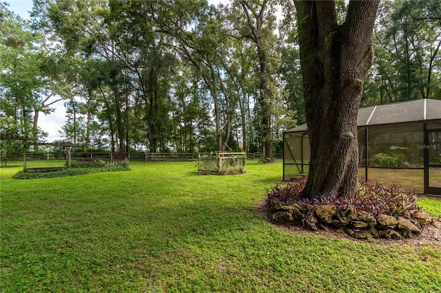 view of yard with fence and a lanai