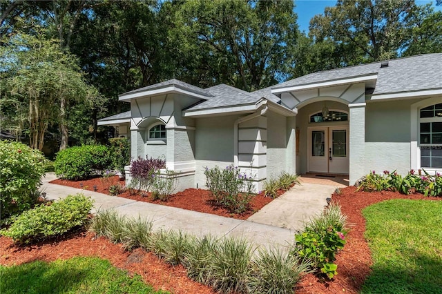 view of front of house with roof with shingles and stucco siding