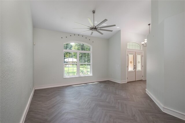 unfurnished room featuring ceiling fan with notable chandelier and dark parquet floors