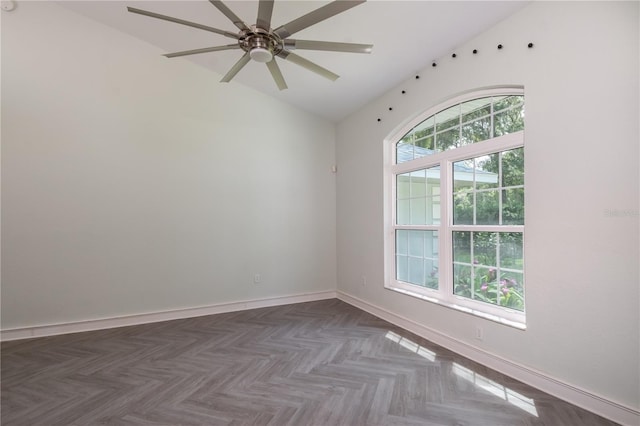 empty room with a ceiling fan, lofted ceiling, and baseboards