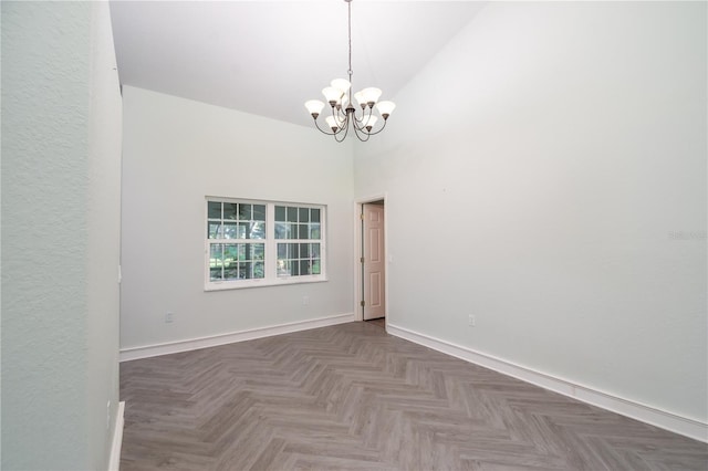 empty room featuring high vaulted ceiling, parquet flooring, and an inviting chandelier