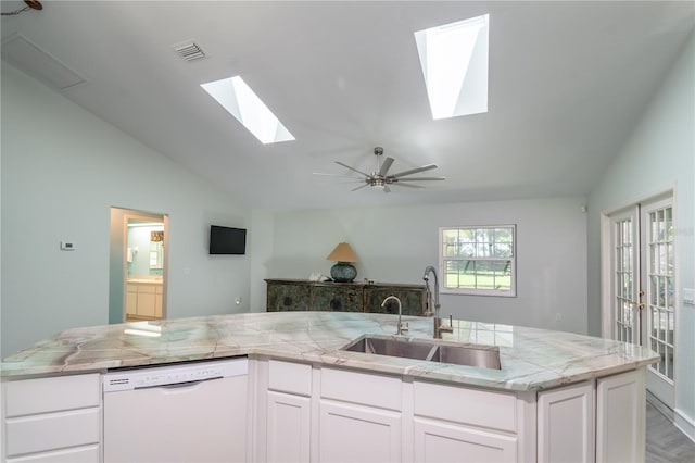 kitchen featuring white dishwasher, a sink, visible vents, white cabinets, and light stone countertops