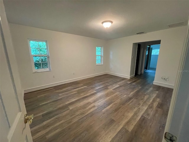 spare room featuring a textured ceiling and dark wood-type flooring