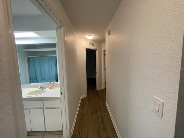 hallway featuring hardwood / wood-style flooring and sink