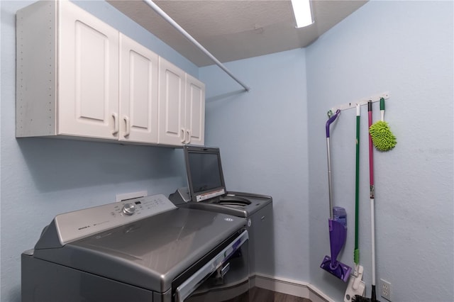 washroom featuring hardwood / wood-style flooring, cabinets, and washing machine and dryer